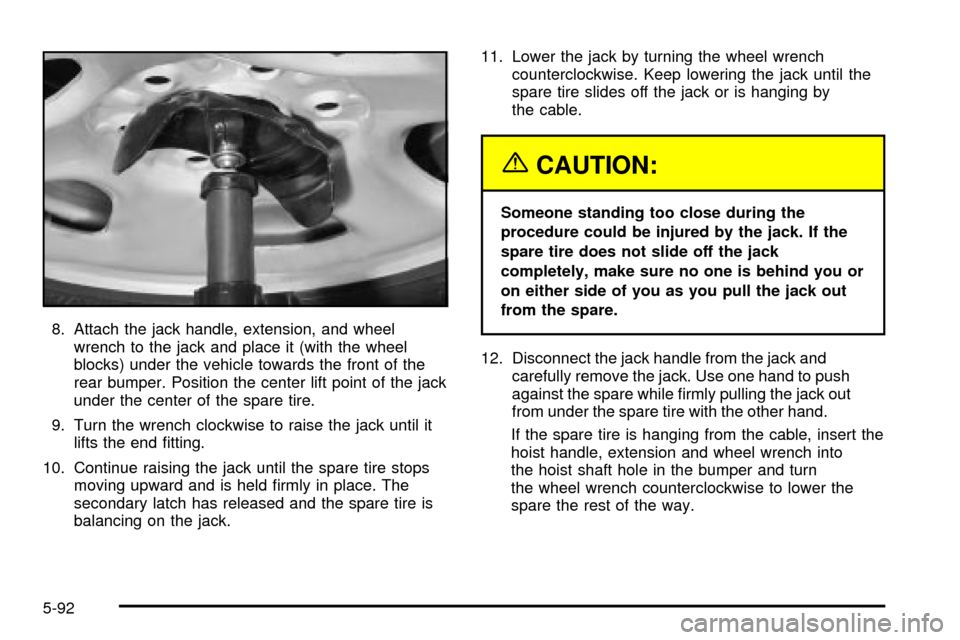 CADILLAC ESCALADE 2003 2.G Owners Manual 8. Attach the jack handle, extension, and wheel
wrench to the jack and place it (with the wheel
blocks) under the vehicle towards the front of the
rear bumper. Position the center lift point of the ja CADILLAC ESCALADE 2003 2.G Owners Manual 8. Attach the jack handle, extension, and wheel
wrench to the jack and place it (with the wheel
blocks) under the vehicle towards the front of the
rear bumper. Position the center lift point of the ja